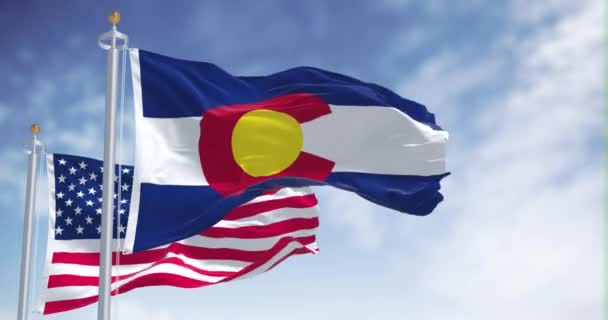 科罗拉多州的国旗与美利坚合众国国旗一同飘扬 在背景上有一个晴朗的天空 4K分辨率 — 图库视频影像