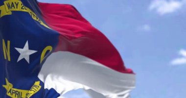 Amerika Birleşik Devletleri Kuzey Carolina bayrağı rüzgarda sallanıyor. Kuzey Carolina, ABD 'nin güneydoğu bölgesinde bulunan bir eyalettir. Demokrasi ve bağımsızlık. Yavaş çekimde kusursuz döngü. 4k çözünürlüğü