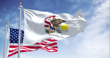 Illinois eyalet bayrağı, Amerika Birleşik Devletleri bayrağıyla birlikte dalgalanıyor. Arka planda açık bir gökyüzü var. Illinois, ABD 'nin orta batısında bulunan bir eyalettir.