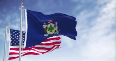 Maine eyaleti bayrağı, Amerika Birleşik Devletleri bayrağıyla birlikte dalgalanıyor. Arka planda açık bir gökyüzü var. Maine, ABD 'nin New England bölgesinde bir eyalettir.