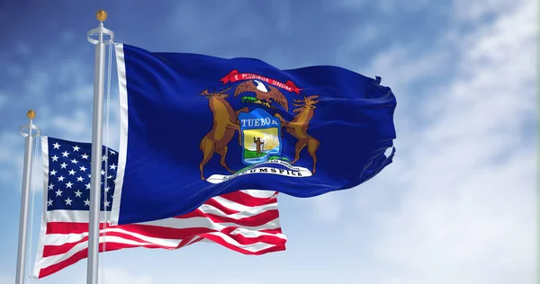 密歇根州的国旗与美利坚合众国国旗一同飘扬 在背景上有一个晴朗的天空 密歇根州是美国中西部的一个州 — 图库照片