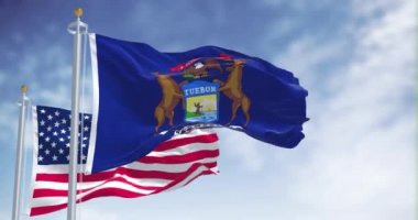Michigan eyalet bayrağı, Amerika Birleşik Devletleri bayrağıyla birlikte dalgalanıyor. Arka planda açık bir gökyüzü var. Michigan, ABD 'nin orta batısında bulunan bir eyalettir.