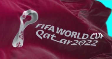 Doha, Katar, Nisan 2022: Katar 2022 Fifa Dünya Kupası logosu rüzgarda dalgalanan bir bayrak. Etkinlik 21 Kasım - 18 Aralık 2022 tarihleri arasında Katar 'da gerçekleşecek.