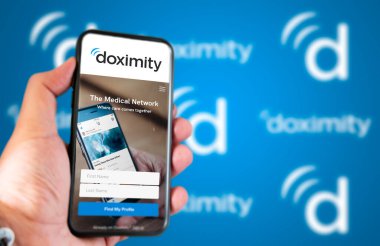 San Francisco, CA, USA March 2022: Doximity company website on a phone screen. Blue background with Doximity logo blurred in the background. Illustrative editorial. Selective focus.