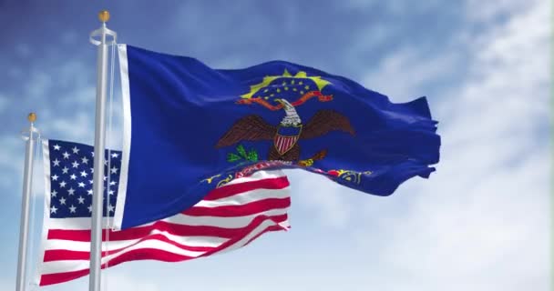 北达科他州的国旗与美利坚合众国国旗一同飘扬 在背景上有一个晴朗的天空 北达科他州是美国中西部的一个州 — 图库视频影像