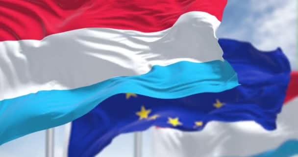 Detalle Bandera Nacional Luxemburgo Ondeando Viento Con Borrosa Bandera Unión — Vídeos de Stock