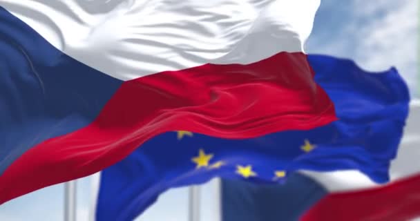 チェコ共和国の国旗のシームレスなループは 晴れた日に背景にぼやけた欧州連合の旗で風に振っています 民主主義と政治 ヨーロッパの国 選択的焦点 — ストック動画