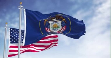The Utah state flag waving along with the national flag of the United States of America. Utah is a state in the Mountain West subregion of the Western United States