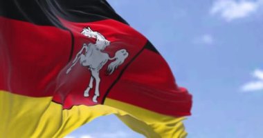 Yavaş çekimde kusursuz döngü, açık bir günde rüzgarda dalgalanan Lower Saxony bayrağı. Aşağı Saksonya, Almanya 'nın kuzeybatısında bulunan bir Alman devletidir.
