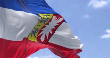 Yavaş çekimde kusursuz döngü, açık bir günde rüzgarda dalgalanan Schleswig-Holstein bayrağı. Holstein-Holstein, Almanya 'nın kuzeyinde Schleswig-Holstein eyâletinde,