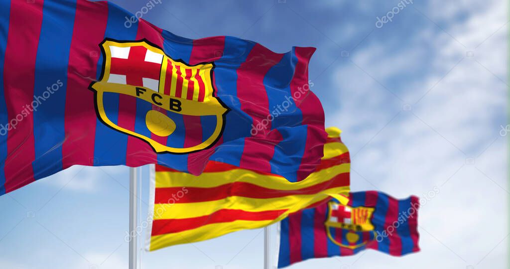 Barcelona, Spain, May 2022: two flags of FC Barcelona are waving in the wind with the Catalonia flag in the middle