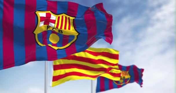 スペイン バルセロナ2022年5月 Fcバルセロナの2本の旗が中央のカタルーニャの旗で風になびいています スローモーションでのシームレスなループ — ストック動画