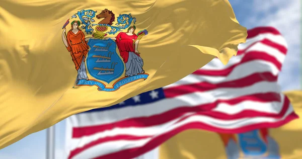 ニュージャージー州旗はアメリカ合衆国の国旗と共に振っている 背景には澄んだ空が広がっています ニュージャージー州は米国北東部の州です — ストック写真