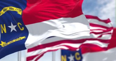 Kuzey Carolina bayrağı, Amerika Birleşik Devletleri bayrağıyla birlikte dalgalanıyor. Yavaş çekimde kusursuz döngü. Kuzey Carolina, ABD 'nin güneydoğu bölgesinde bir eyalettir.