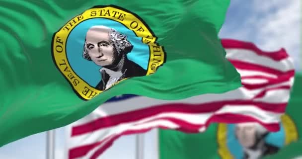 ワシントン州の旗はアメリカ合衆国の国旗と共に振っている ワシントン州は西アメリカの太平洋岸北西部に位置する州である スローモーションでのシームレスなループ — ストック動画