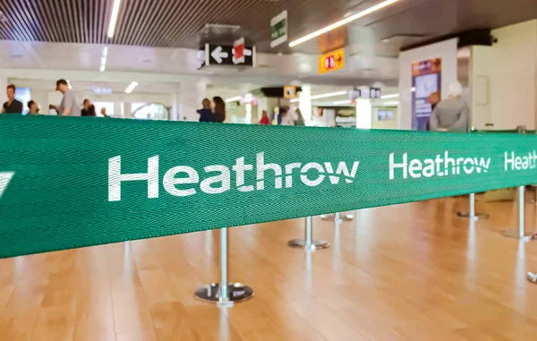 ロンドン 2022年5月 ホワイトロンドンヒースロー国際空港のロゴが入ったグリーンベルトバリア アメリカン航空はアメリカの主要航空会社である 旅行と空港のセキュリティ — ストック写真
