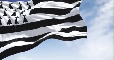 Açık bir günde rüzgarda dalgalanan Britanya bayrağının görüntüsü. Brittany, Fransa 'nın batısında yer alan tarihi bir yarımadadır. Seçici odaklanma. Yavaş çekimde kusursuz döngü