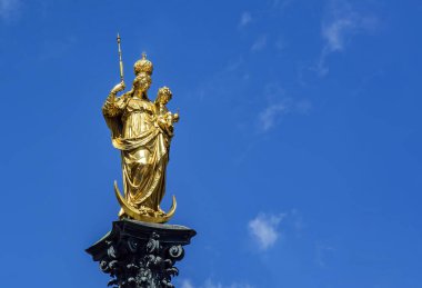 Mariensaule 'nin Münih Marienplatz' daki heykeli. Mariensaule, Hilal ay üzerinde duran Meryem ve Çocuk İsa 'nın resmedildiği altın renkli bir heykeldir.