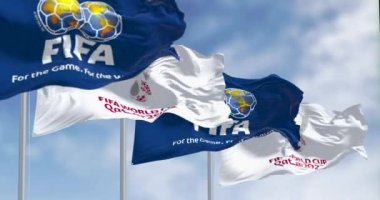 Doha, Qatar, April 2022: Flags with Qatar 2022 World Cup logo and FIFA waving in the wind. The event is scheduled in Qatar from 21 November to 18 December 2022. Seamless loop in slow motion