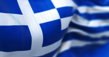 Close-up view of the greek national flag waving in the wind. Greece is a country at the crossroads of Central and Southeast Europe. Fabric textured background. Selective focus