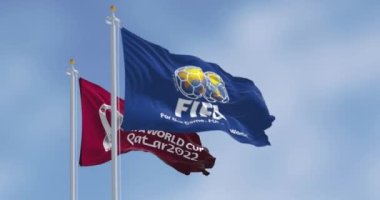 Doha, Qatar, January 2022: Flags with FIFA and Qatar 2022 World Cup logo waving in the wind. The event is scheduled in Qatar from 21 November to 18 December 2022. Slow motion