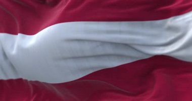Close-up view of the austrian national flag waving in the wind. Austria is a landlocked country of Central Europe. Fabric textured background. Selective focus. Seamless loop in slow motion
