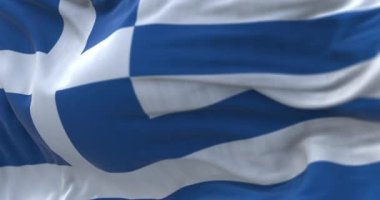 Close-up view of the greek national flag waving in the wind. Greece is a country in Southeast Europe. Fabric textured background. Selective focus. Seamless loop in slow motion