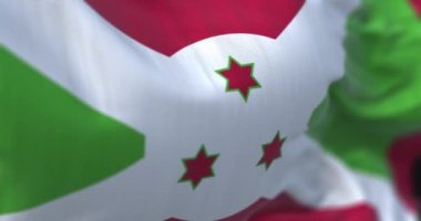 Burundi ulusal bayrağının dalgalanma görüntüsü. Burundi Cumhuriyeti, Afrika kıtasında bulunan bir ülkedir. Kumaş desenli arka plan. Seçici odaklanma. Yavaş çekimde kusursuz döngü