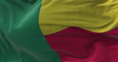 Benin ulusal bayrağının rüzgarda dalgalanırken yakın plan görüntüsü. Benin Cumhuriyeti Batı Afrika 'da bir ülkedir. Kumaş desenli arka plan. Seçici odaklanma. Yavaş çekimde kusursuz döngü