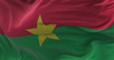 Burkina Faso ulusal bayrağının rüzgarda dalgalanmasını yakından izliyoruz. Burkina Faso, Batı Afrika 'da bir ülkedir. Kumaş desenli arka plan. Seçici odaklanma. Yavaş çekimde kusursuz döngü