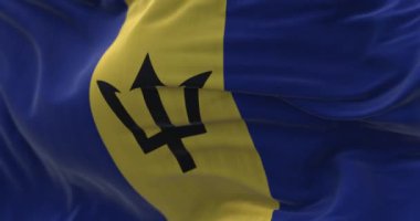 Rüzgarda dalgalanan Barbados ulusal bayrağının yakın çekim görüntüsü. Barbados, Batı Hint Adaları 'nın Küçük Antilleri' nde bir ada ülkesidir. Kumaş desenli arka plan. Seçici odaklanma. Yavaş çekimde kusursuz döngü