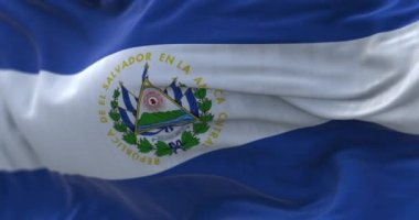 El Salvador ulusal bayrağının rüzgarda dalgalandığı yakın plan görüntüsü. El Salvador Cumhuriyeti bir Güney Amerika devletidir. Kumaş desenli arka plan. Seçici odaklanma. Yavaş çekimde kusursuz döngü