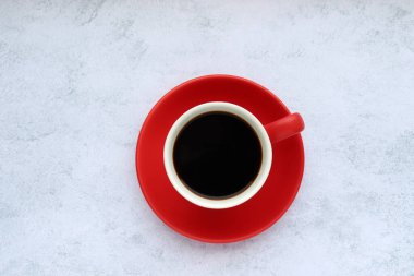 Kırmızı fincan siyah americano, espresso kahvesi gri beton arka planda. Üst görünüm, alanı kopyala