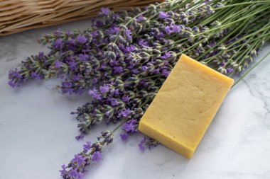 Lavanta sabun ve lavanta çiçekleri beyaz mermer masa arkasında. Güzellik ve kişisel bakım konsepti. Üst görünüm, düz görünüm, kopyalama alanı