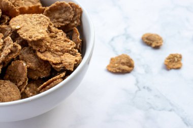 Bir kase çoklu tahıllı mısır gevreği ve mermer masa arkası kaşığı. Sağlıklı diyet kahvaltısı. Üst görünüm, alanı kopyala