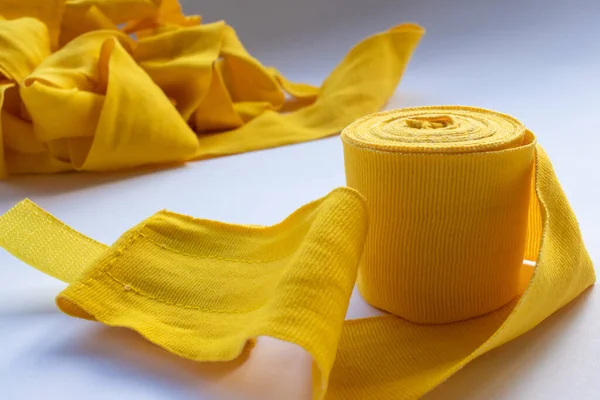 Yellow boxing hand bandage wraps on white background. Sports equipment for boxing. Top view, copy space