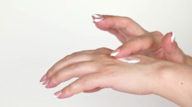 on a light background female hands smear cream