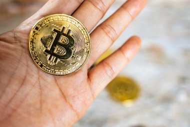 Elinde bitcoin sembolü olan bir altın sikkeyi kapat. Genç el kripto para, para dijital para, BTC.