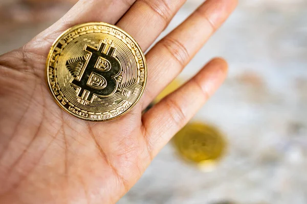 Elinde bitcoin sembolü olan bir altın sikkeyi kapat. Genç el kripto para, para dijital para, BTC.