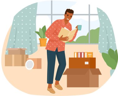 Kitap okuyan genç adam masanın yanında duruyor, evde ders çalışıyor.