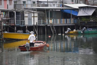 Küçük Hong Kong adası Peng Chau 'da Asyalı bir adam kayığa biniyor. 