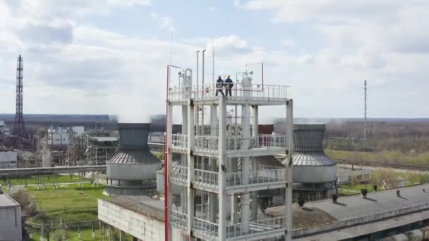 Los ingenieros están en el gran edificio industrial. Tubos industriales de humo de chimenea de la planta. Chemical Plant expulsa una nube de vapor. Contaminación ambiental. Emisiones químicas a la atmósfera. — Vídeos de Stock