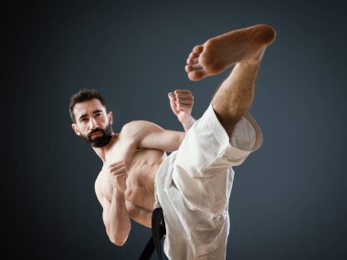 Bir Sensei Karateka eğitmeni dövüş okulunda tek başına antrenman yapar ve mükemmel bir yan tekme atar.