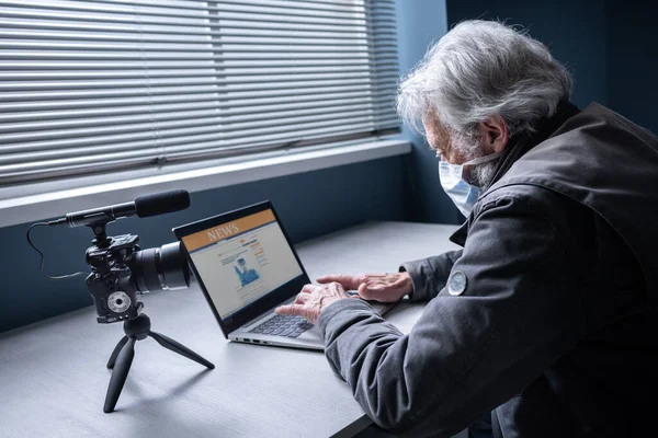 Starší Muž Který Sedí Stolem Sobě Chirurgickou Masku Připojuje Svému — Stock fotografie