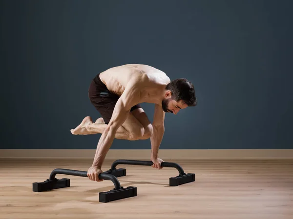A calisthenics instructor trains alone at home for a perfect performance with Push up Bars