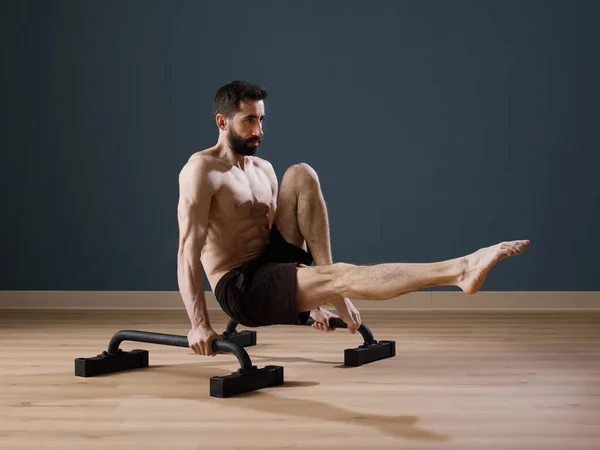 A calisthenics instructor trains alone at home for a perfect performance with Push up Bars