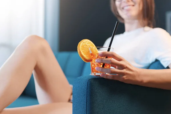 快乐的年轻女人在家里休息 她正坐在沙发上喝酒 — 图库照片