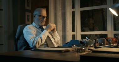 Profesör yazar tıkanıklığıyla mücadele ediyor: masada oturuyor ve iyi fikirlere sahip olamıyor