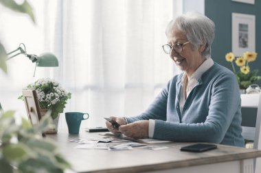 Masada oturup eski resimlere bakarken mutlu bir son sınıf öğrencisi.