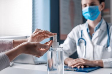 Hastanın ellerini antibakteriyel jel, koronavirüs önleyici kullanarak sterilize ediyor.
